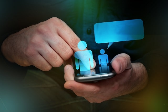 Person using mobile device with social and chat icons